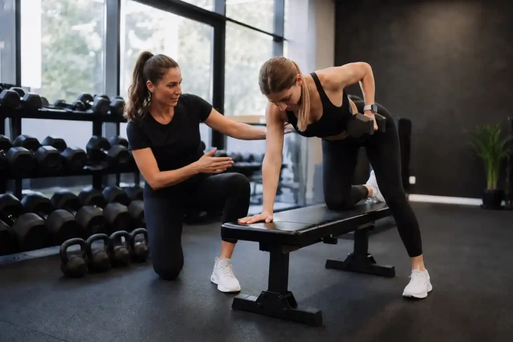 Personal trainer coaching a client through strength training exercises in a modern fitness studio
